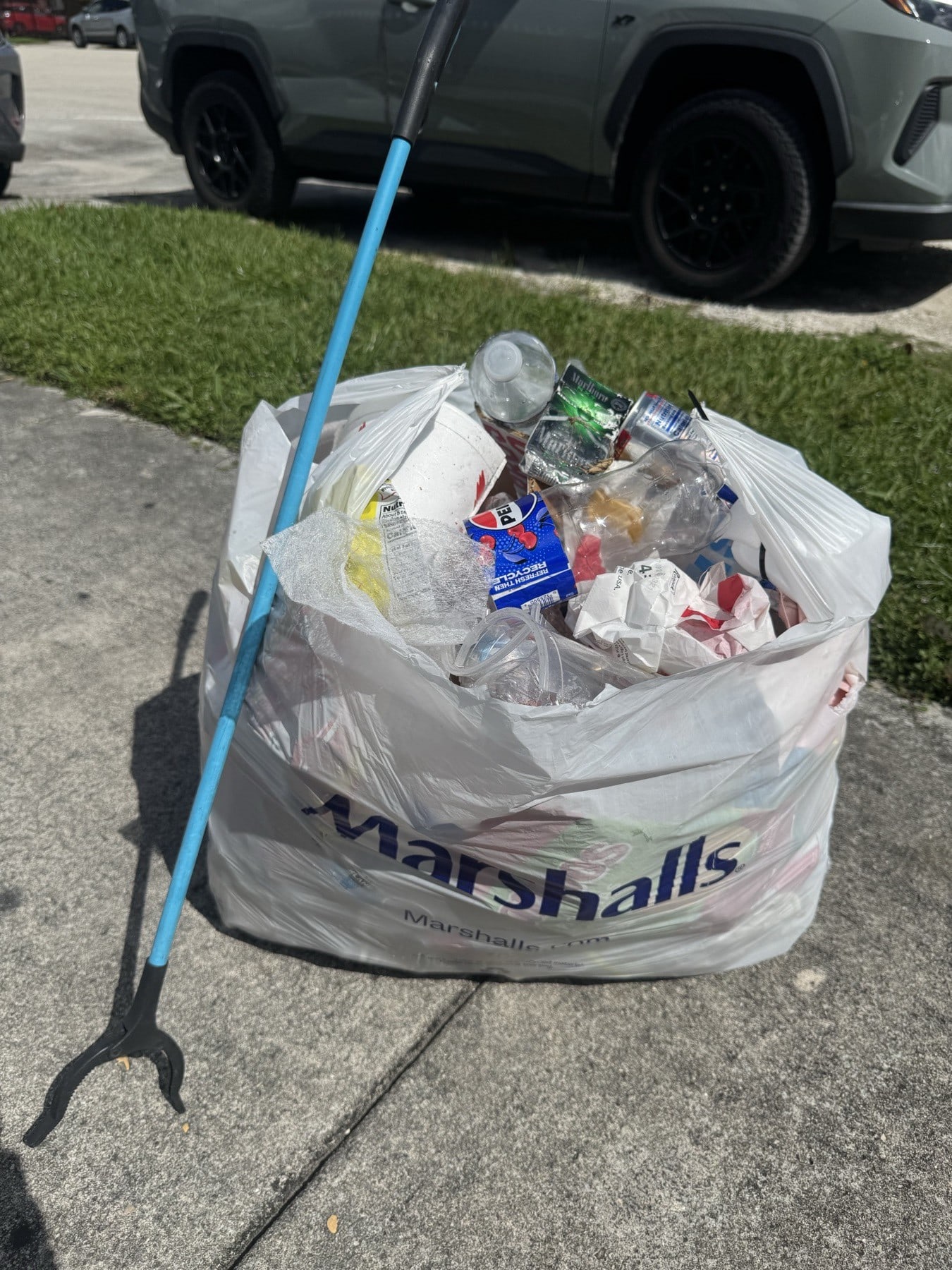 A bag of bottles and cans collected in a parking lot